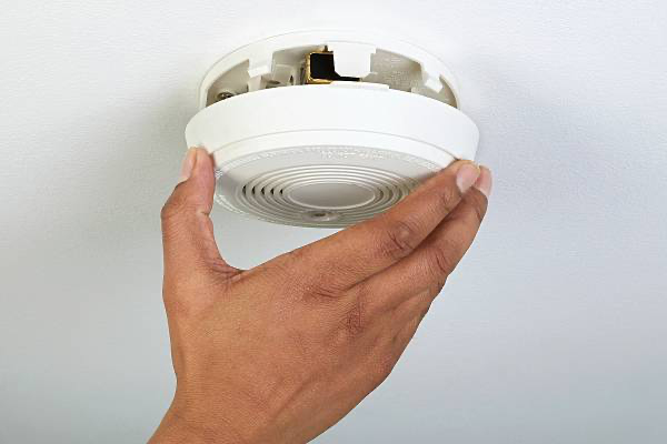 Expert technician ensuring smoke detector compliance for Melbourne commercial building